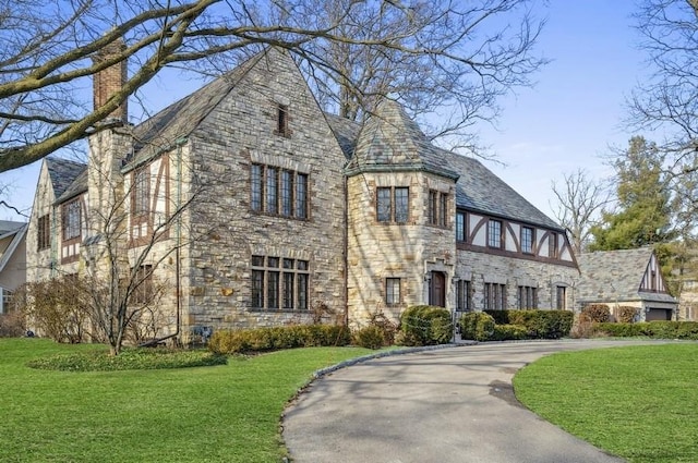 english style home with a front lawn