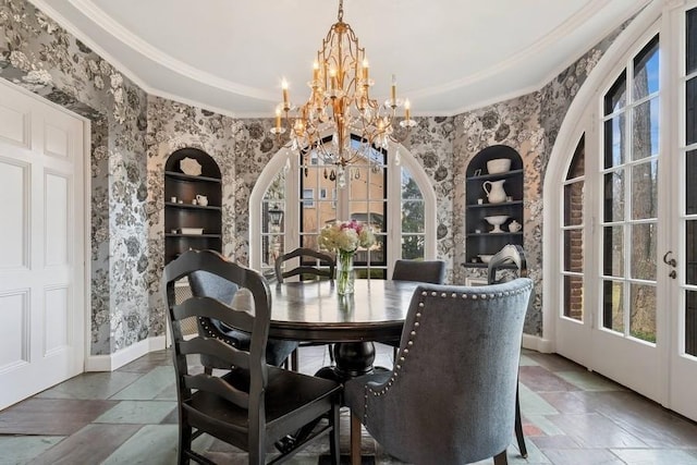 dining space with a notable chandelier, crown molding, built in features, and french doors