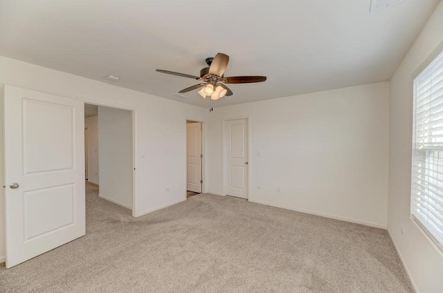 empty room featuring ceiling fan and light colored carpet