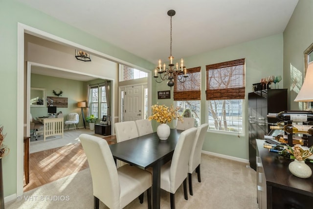 dining area featuring light carpet and a chandelier