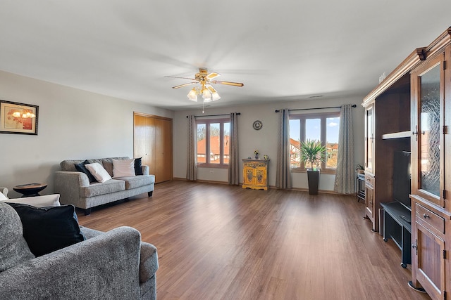 living room with dark wood-type flooring and ceiling fan