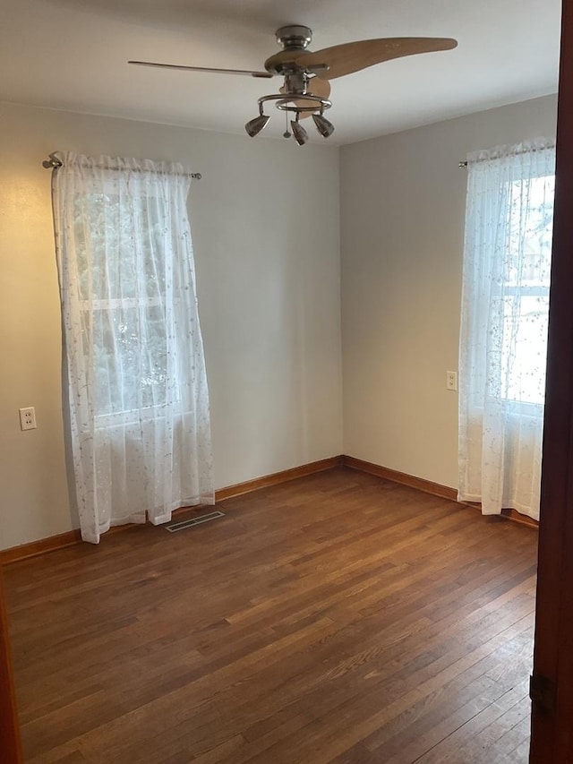 unfurnished living room with dark hardwood / wood-style flooring and ceiling fan