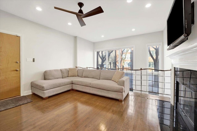 living room featuring hardwood / wood-style floors and ceiling fan