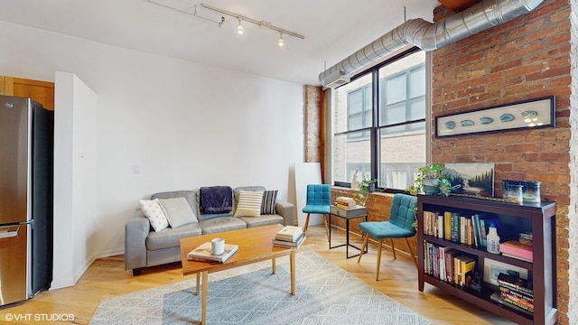 living room with light hardwood / wood-style floors, track lighting, and a fireplace