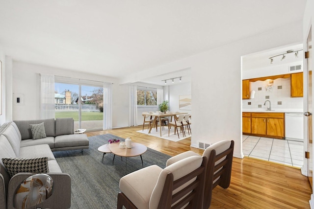 living room featuring sink and light hardwood / wood-style flooring