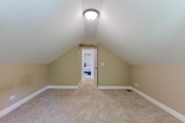 additional living space with lofted ceiling and light carpet