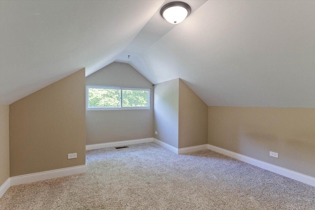 additional living space with lofted ceiling and light carpet