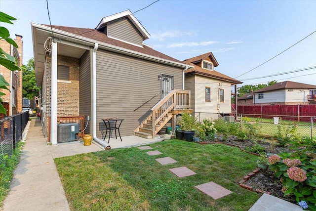 back of property featuring a patio area, cooling unit, and a lawn