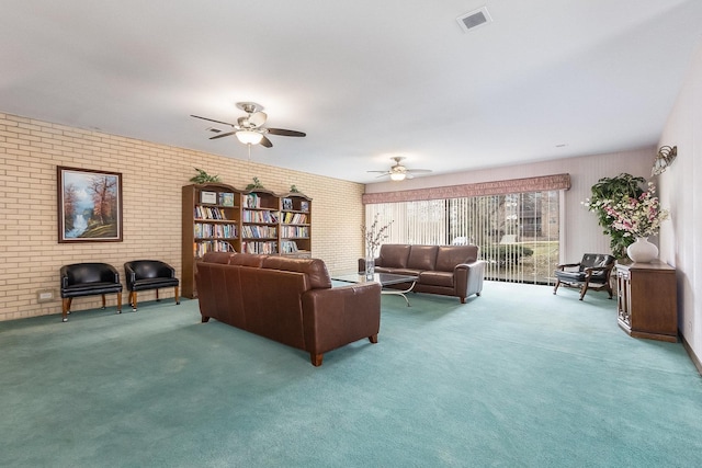 living room with ceiling fan, brick wall, and carpet