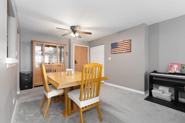 carpeted dining area with ceiling fan