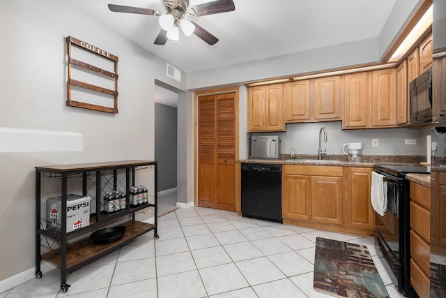 kitchen with sink, light tile patterned floors, ceiling fan, dark stone counters, and black appliances