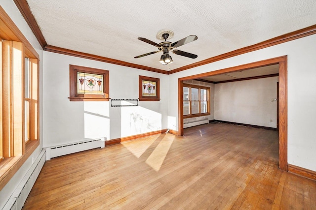 spare room featuring light wood-type flooring, ornamental molding, a baseboard radiator, and a textured ceiling