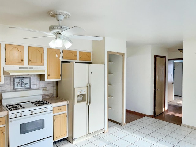 kitchen featuring white appliances, tasteful backsplash, light tile patterned floors, ceiling fan, and tile countertops