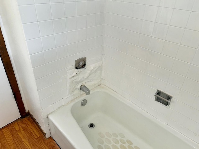 bathroom with wood-type flooring and a bathtub