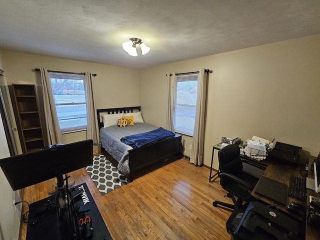 bedroom with hardwood / wood-style flooring and a textured ceiling