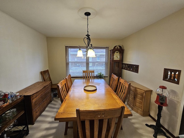 dining space featuring an inviting chandelier and light colored carpet