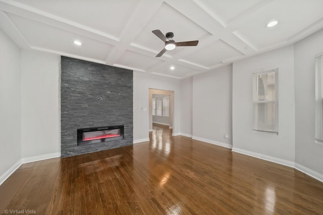 unfurnished living room featuring a fireplace, dark wood-type flooring, beam ceiling, and coffered ceiling