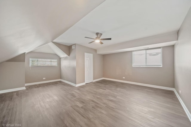 additional living space with lofted ceiling, hardwood / wood-style floors, and ceiling fan