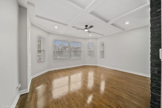 spare room with coffered ceiling, beamed ceiling, ceiling fan, and dark hardwood / wood-style flooring