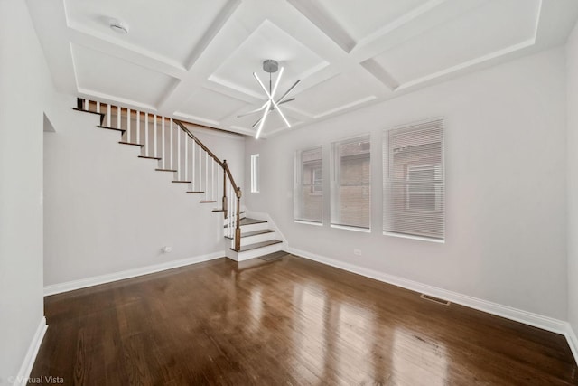 unfurnished living room featuring dark wood-type flooring, beam ceiling, a notable chandelier, and coffered ceiling