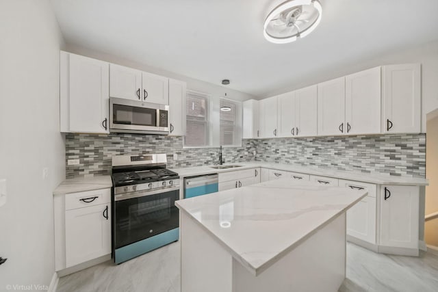 kitchen featuring a center island, appliances with stainless steel finishes, white cabinetry, decorative backsplash, and sink