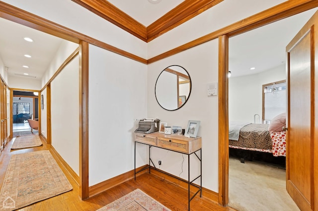 hall featuring crown molding and light hardwood / wood-style floors