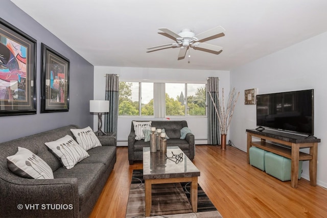 living room featuring ceiling fan, hardwood / wood-style floors, and a baseboard heating unit