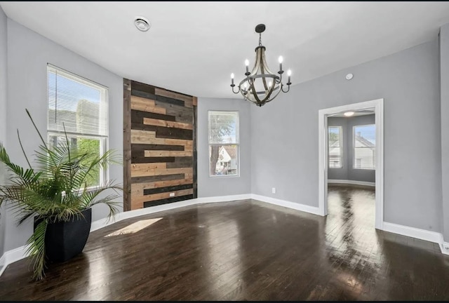 dining room with an inviting chandelier, dark wood-type flooring, and plenty of natural light