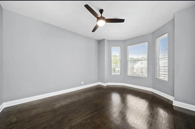 empty room with dark hardwood / wood-style flooring and ceiling fan