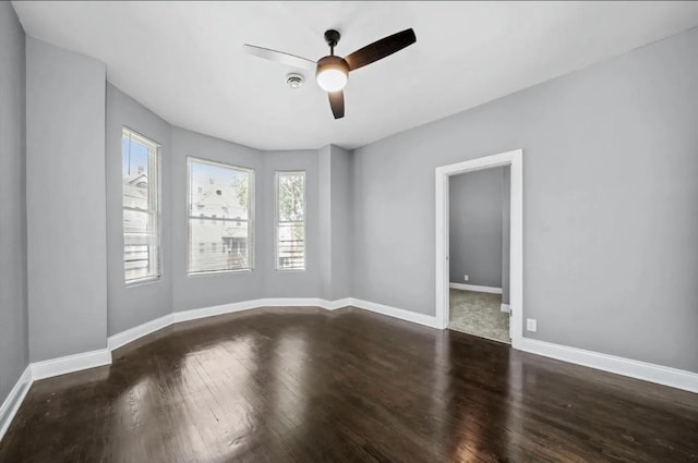 unfurnished room featuring dark wood-type flooring and ceiling fan