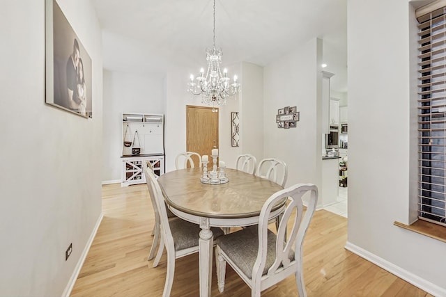 dining room featuring light wood-type flooring and a chandelier