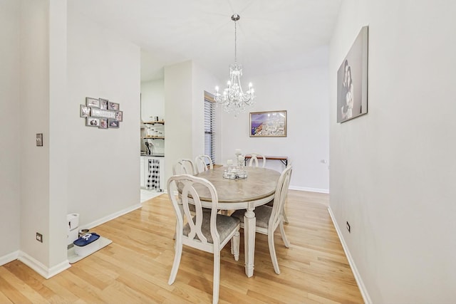 dining area featuring hardwood / wood-style floors and an inviting chandelier