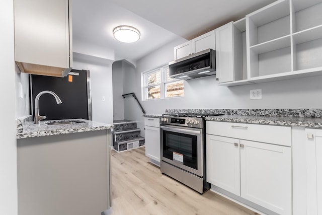 kitchen featuring light hardwood / wood-style flooring, appliances with stainless steel finishes, sink, white cabinets, and light stone countertops