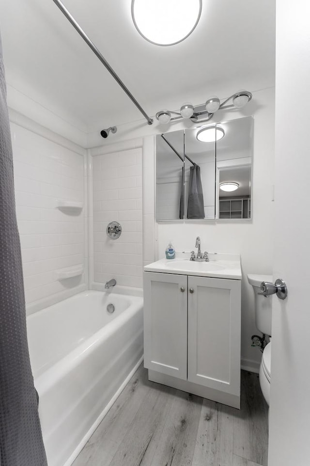 full bathroom featuring wood-type flooring, shower / bath combo with shower curtain, toilet, and vanity