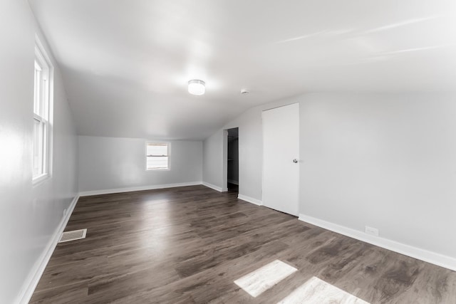 additional living space with vaulted ceiling and dark hardwood / wood-style floors