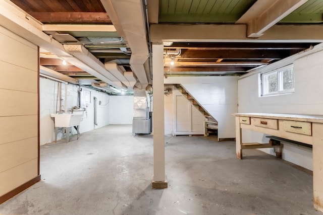 basement featuring sink and heating unit