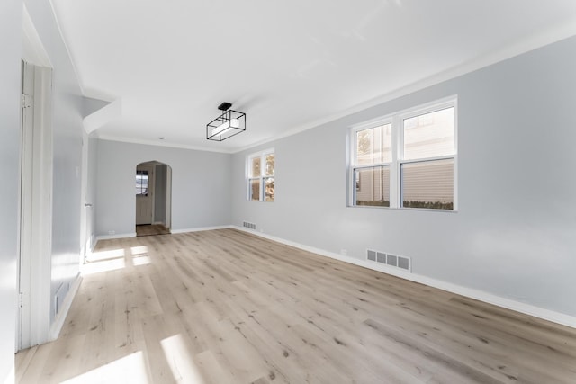 unfurnished room with light wood-type flooring and ornamental molding