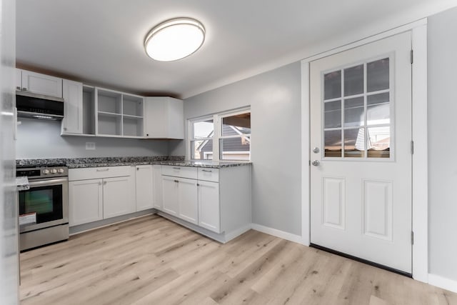 kitchen with range hood, stainless steel range with gas cooktop, a wealth of natural light, and white cabinetry