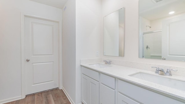 bathroom with hardwood / wood-style flooring, walk in shower, and vanity