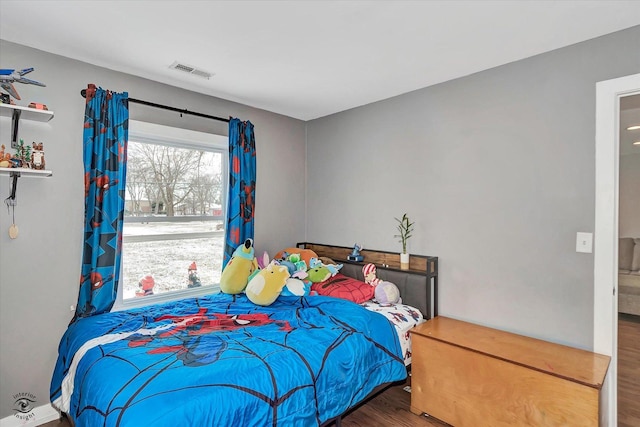 bedroom with hardwood / wood-style flooring and multiple windows