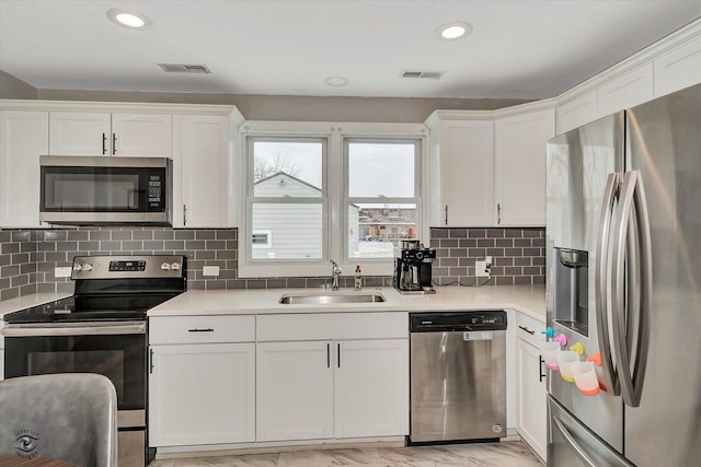 kitchen featuring appliances with stainless steel finishes, sink, and white cabinets