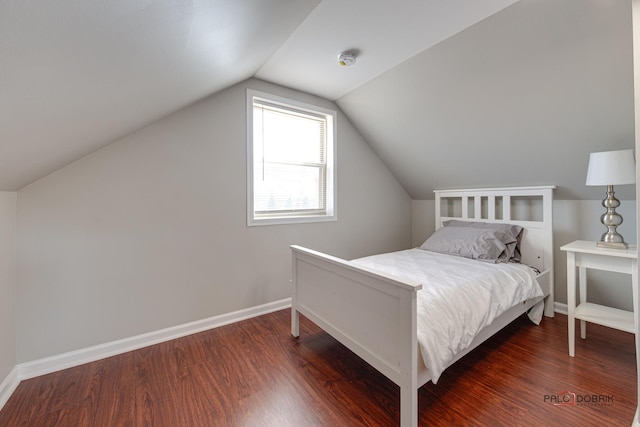 bedroom with dark hardwood / wood-style floors and lofted ceiling