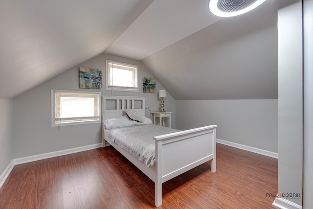 bedroom with dark wood-type flooring and vaulted ceiling