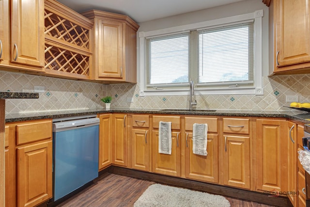 kitchen featuring stainless steel dishwasher, sink, dark stone countertops, dark hardwood / wood-style flooring, and backsplash