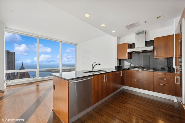 kitchen featuring appliances with stainless steel finishes, exhaust hood, sink, kitchen peninsula, and a water view