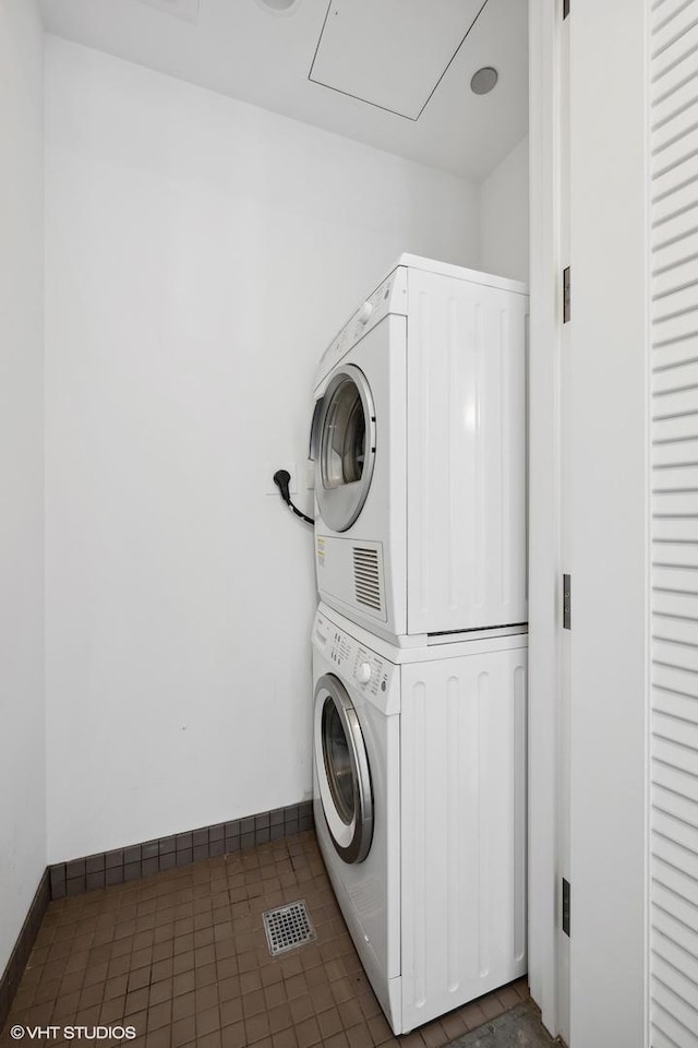 clothes washing area featuring stacked washer / dryer