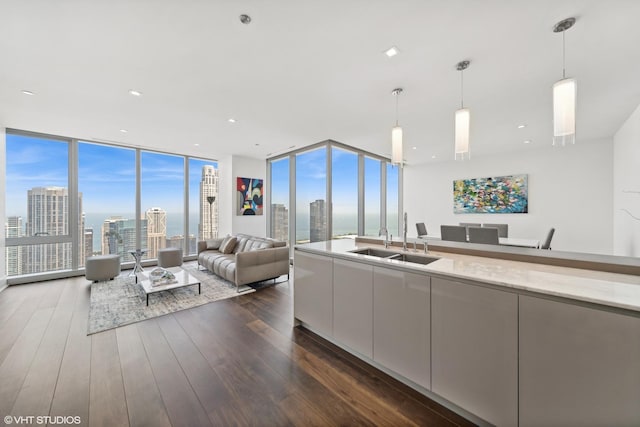 kitchen with floor to ceiling windows, sink, hanging light fixtures, and dark hardwood / wood-style floors