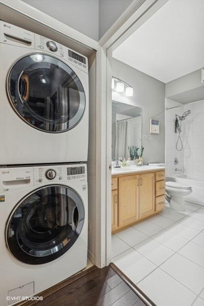 laundry area with sink and stacked washer / dryer