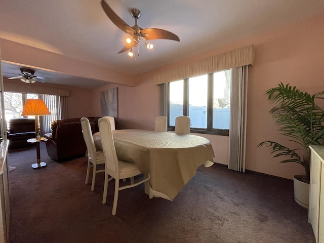 dining area featuring a water view, ceiling fan, and dark colored carpet