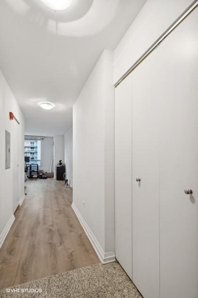 hallway with electric panel and wood-type flooring